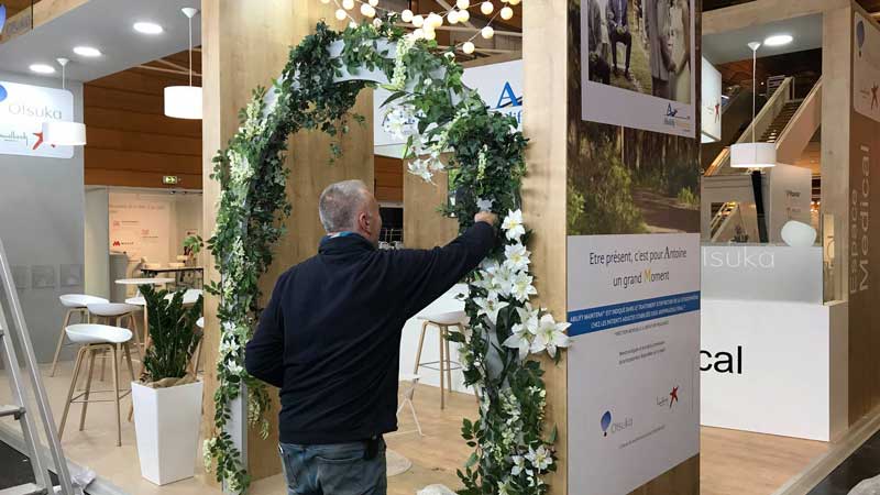 Installation d'une arche végétale fleurie sur un stand